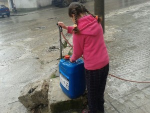 طفلة تعمل على نقل المياه من أحد المناهل العامة المنتشرة في شوارع إدلب تصوير مها رباح