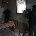 A Free Army sniper surveys the movement of regime forces in the area of Aleppo International Airport