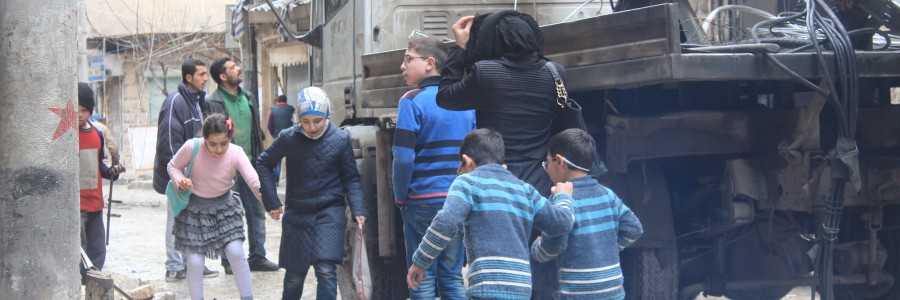 7- أمّ مع أطفالها تحاول رؤية منزلها الذي تعرض للقصف في حي المشهد في مدينة حلب. تصوير صلاح الأشقر